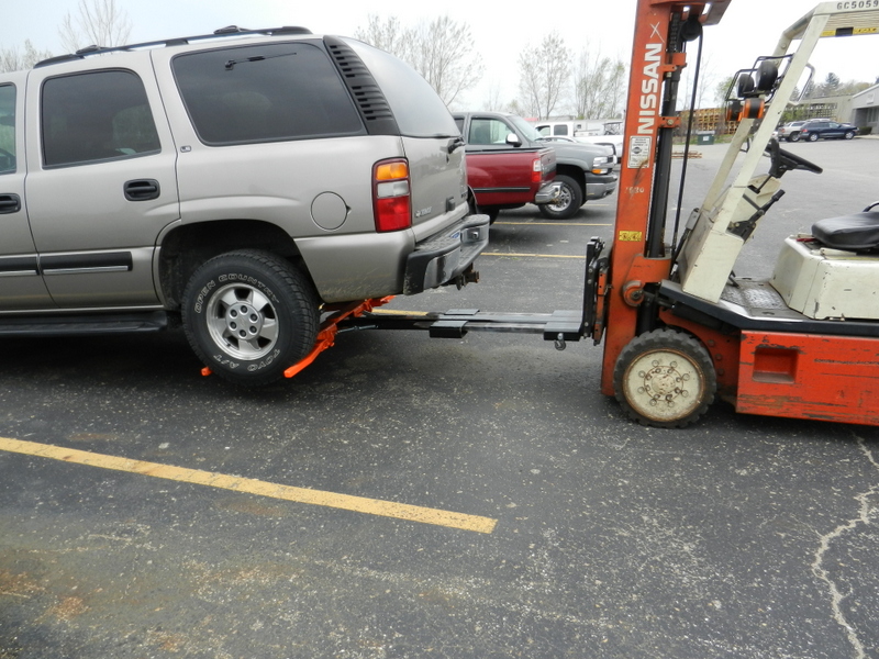 Forklift wrecker lifting an suv